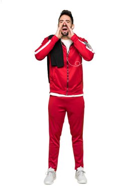 Tam uzunlukta bağırarak ve izole beyaz arka planda bir şey ilan yakışıklı sportman kadeh