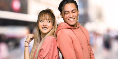 Genç çift şehirde bir gülümseme ile omuz üzerinden bakıyor