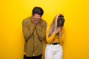 Yorgun ve hasta ifade ile canlı sarı arka plan üzerinde Genç çift