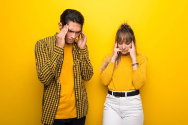 Canlı sarı arka plan üzerinde Genç çift mutsuz ve bir şey ile sinirli