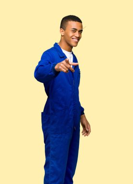 Genç afro Amerikan işçi adam puan parmak size izole arka plan üzerinde kendine güvenen bir ifade ile