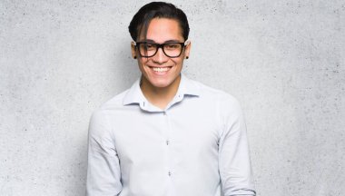 Gözlüklü yakışıklı adam ve dokulu duvar arka plan mutlu