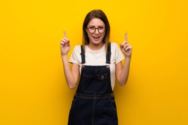 Harika bir fikir işaret parmağı ile işaret sarı duvarın üzerinden kadın