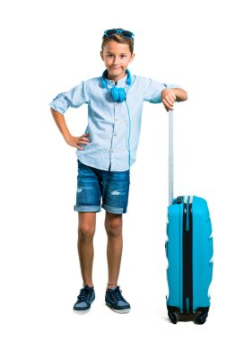 Çocuk tam vücut güneş gözlüğü ve kulaklık bavulunu kalça izole beyaz arka plan üzerinde silah ile poz ile seyahat ile