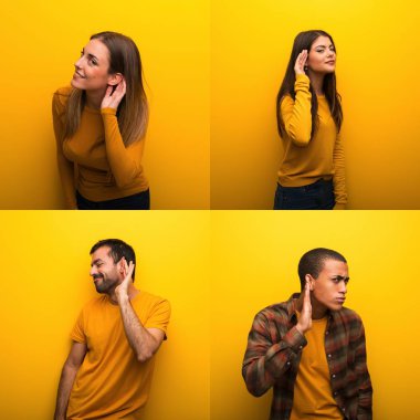 Bir grup insan elini kulağına koyup bir şeyler dinliyor.