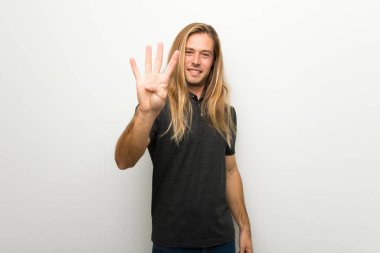 Beyaz duvar mutlu ve sayım dört parmak ile üzerinde uzun saçlı sarışın adam
