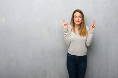 En iyi dilek ve geçiş parmak ile dokulu duvar genç kadın