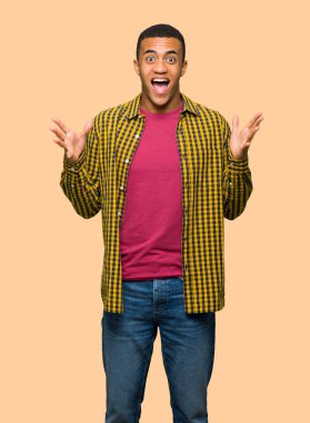 Sürpriz ve yalıtılmış zemin üzerine şok yüz ifadesi ile genç afro Amerikalı adam