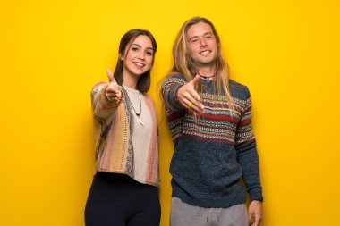 Hippi çift için iyi bir anlaşma kapanış el sıkışan sarı arka plan üzerinde