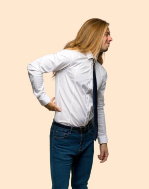 Bir çaba izole arka plan üzerinde yapılmış olan sırt ağrısı muzdarip uzun saçlı sarışın iş adamı