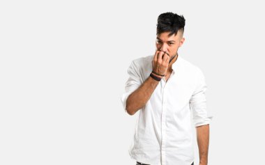 Beyaz gömlekli Arap genç adam biraz gergin ve gri arka planda korkuyor.