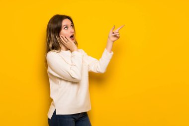 Sarı duvar işaret üzerine genç kız yukarı ve sürpriz