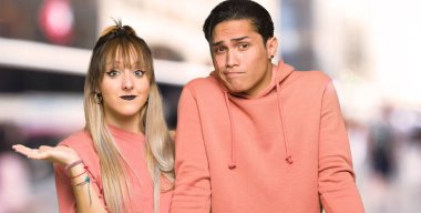 Şehirde el ve omuz kaldırırken şüpheleri olan genç çift