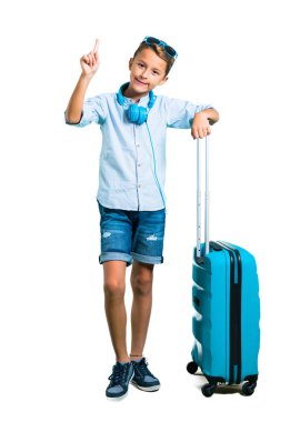 Çocuk tam vücut güneş gözlüğü ve kulaklık bavulunu izole beyaz zemin üzerinde bir numara işareti sayma ile seyahat ile