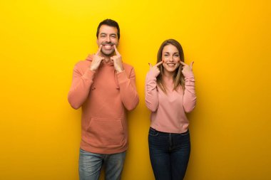 Grup gülümseyen mutlu ve keyifli bir ifadeyle Sarı zemin üzerine iki insan