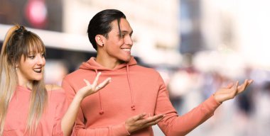 Genç çift şehre gelmeye davet için ellerini yana uzatıyor