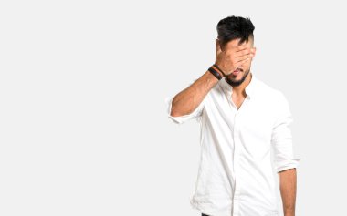 Gri arka planda gözleri kaplayan beyaz gömlekli Arap genç adam.