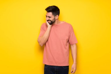 Diş ağrısı ile sarı duvarın üzerinden yakışıklı adam