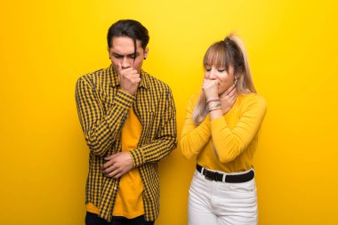 Canlı sarı arka plan üzerinde Genç çift öksürük ve kötü duygu ile acı