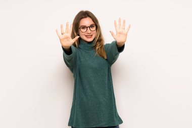 Genç kız beyaz duvar on parmak ile sayma üzerinde