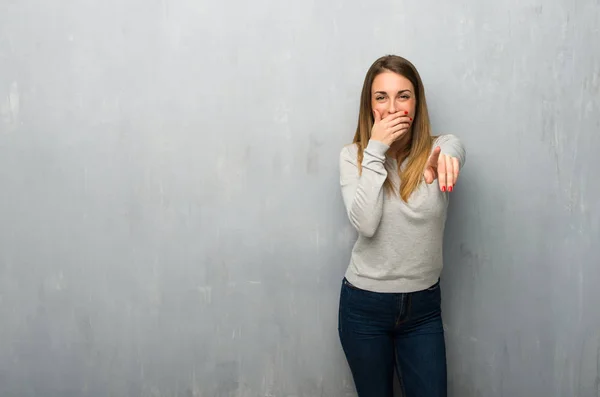 Young Woman Textured Wall Pointing Finger Someone Laughing — Stock Photo, Image