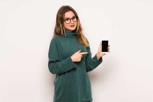 Дівчина Підліток Над Білою Стіною Щаслива Вказує Мобільний — стокове фото