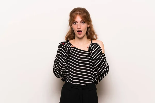 Young redhead woman over white wall with surprise facial expression