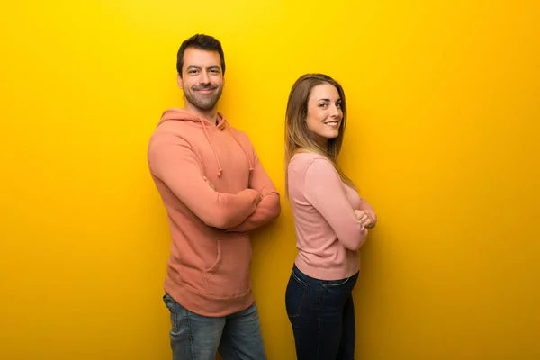 Grupo Dos Personas Sobre Fondo Amarillo Manteniendo Los Brazos Cruzados — Foto de Stock