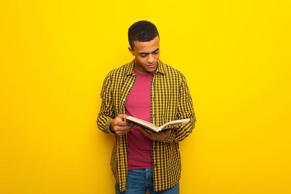 Young Afro American Man Yellow Background Holding Book Enjoying Reading — Stock Photo, Image