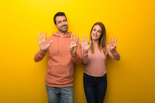 Grupo Duas Pessoas Fundo Amarelo Contando Oito Com Dedos — Fotografia de Stock