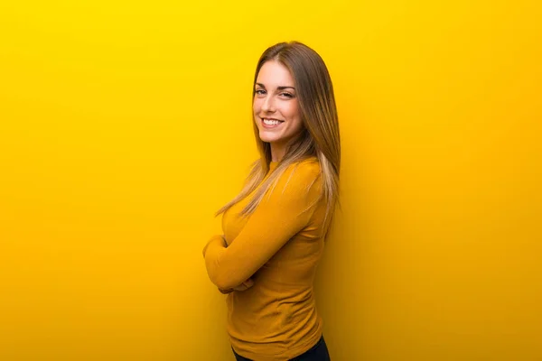 Mujer Joven Sobre Fondo Amarillo Manteniendo Los Brazos Cruzados Posición —  Fotos de Stock