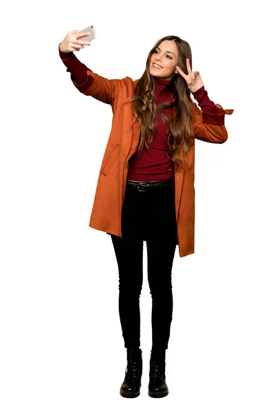 Повнометражний Знімок Молодої Жінки Пальто Щасливим Вказує Мобільний Ізольований Білий — стокове фото