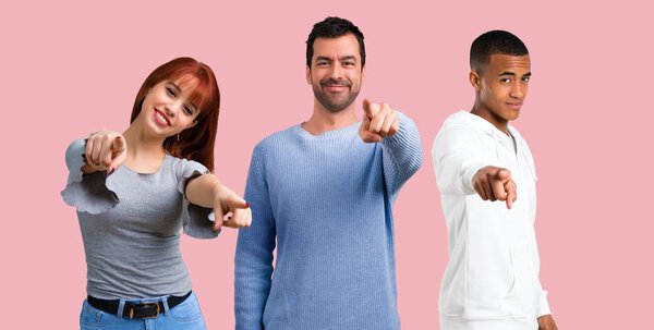 Group of three friends points finger at you