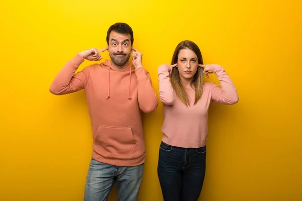 Skupina Dvou Lidí Žlutém Pozadí Zahrnující Obě Uši Rukama — Stock fotografie
