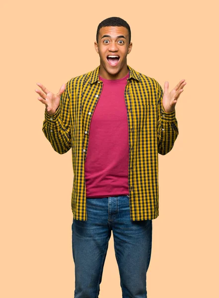 Sürpriz ve yalıtılmış zemin üzerine şok yüz ifadesi ile genç afro Amerikalı adam