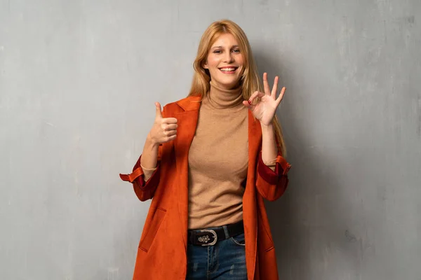 Frau Über Strukturiertem Hintergrund Zeigt Zeichen Mit Und Gibt Einen — Stockfoto