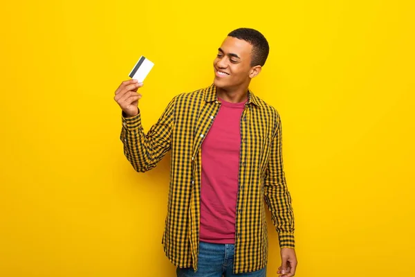 Afro American Młodzieńca Żółtym Tle Posiadania Karty Kredytowej Myślenia — Zdjęcie stockowe