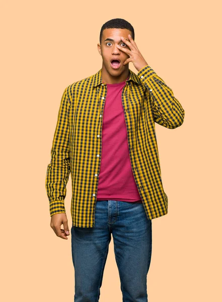 Sürpriz ve yalıtılmış zemin üzerine şok yüz ifadesi ile genç afro Amerikalı adam