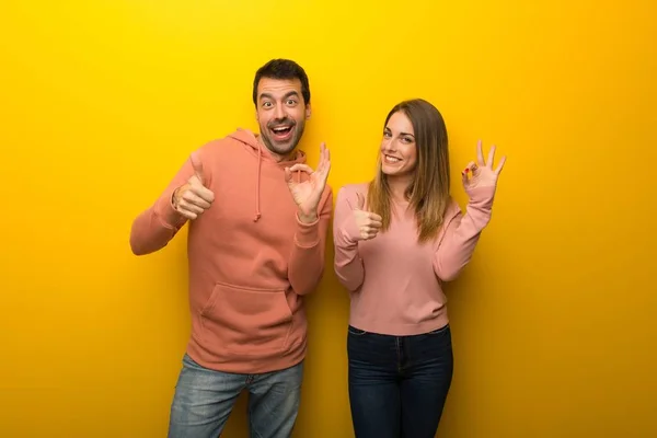 Группа Двух Человек Желтом Фоне Показывает Знак Показывает Большой Палец — стоковое фото