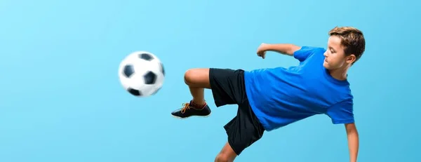 Boy playing soccer kicking the ball