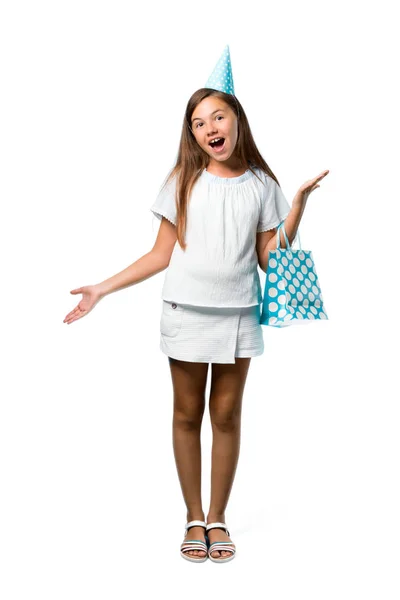 驚きとショックを受けた表情分離の白い背景の上のギフト袋を保持している誕生日パーティーで少女のフルレングス ショット — ストック写真