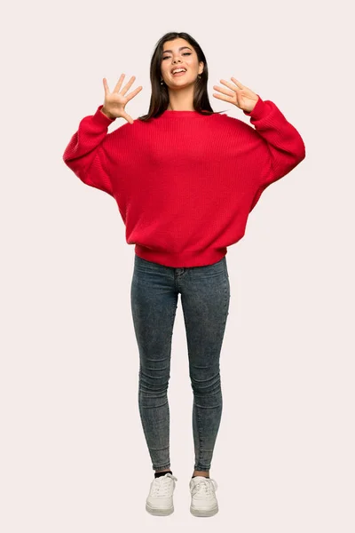 孤立した背景の上 本の指を数える赤いセーターとティーンエイ ジャーの女の子のフルレングス ショット — ストック写真