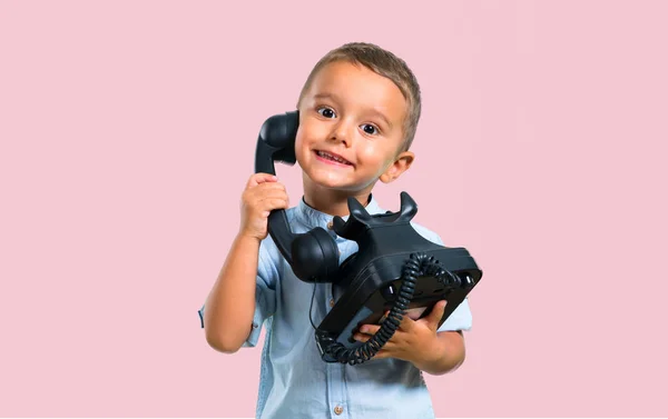 Little kid talking to vintage phone on color baackground