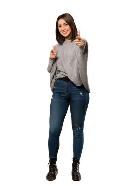 İzole beyaz arka plan üzerinde gülümseyen genç bir kadın tam uzunlukta bir kadeh parmak seni işaret