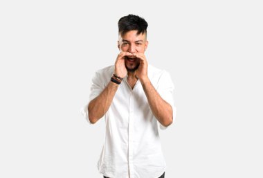 Beyaz gömlekli Arap genç adam, gri arka planda ağzı açık bağırıyor.