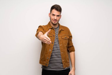 Beyaz duvar iyi bir anlaşma kapanış tokalaşırken yakışıklı adam