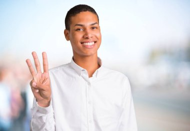 Parmakları odaklanmamış açık arka plan üzerinde beyaz gömlek mutlu ve sayım üç genç Afro-Amerikan adamla