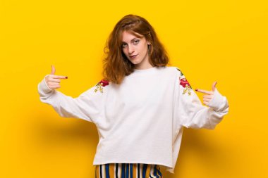 Sarı duvar gurur ve halinden memnun içinde genç Kızıl saçlı kadın kendini kavram seviyorum