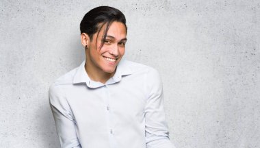 Dokulu duvar arka plan üzerinde omuzkaldırma sırasında önemsiz jest yapan yakışıklı adam