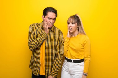 Diş ağrısı ile canlı sarı arka plan üzerinde genç çift